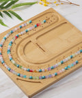Bamboo Bead Board for Jewelry Making With 3 U Shaped Grooves And 4 Storage Slots For Necklace And Bracelet Beading DIY Jewelry Crafting Gear Supplies Kit, showcasing bead layout on a bamboo board.