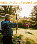 Man using Backyard Archery Target Stand With Adjustable Heights And Ground Pegs, Sturdy Pine Wood, Detachable and Easy To Assemble