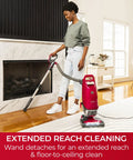 Hassle Free Bagged Upright Vacuum With No Touch Auto Dump And Smooth Lift Up Pod For Stairs on wooden floor near fireplace.