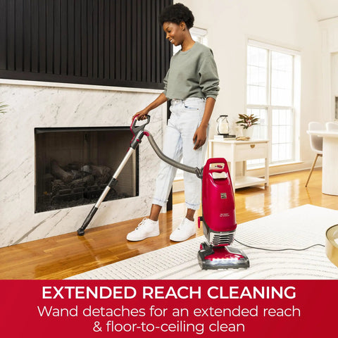 Hassle Free Bagged Upright Vacuum With No Touch Auto Dump And Smooth Lift Up Pod For Stairs on wooden floor near fireplace.