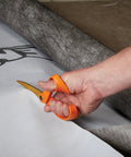 Hand using Titanium Coated Workhorse Shop Shears For All Purpose Yard And Garden Cutting with bright orange handle