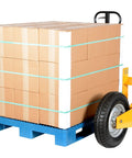 Heavy Duty All Terrain Steel Pallet Truck With Pneumatic Tires And Smooth Steering Glides Over Rough Ground Loads Up To Two Thousand Five Hundred Pounds Without A Sweat On Thirty Two Inch Forks Perfect Yard And Warehouse Workhorse carrying stacked boxes on a blue pallet.