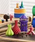 3D printed models with vibrant colors, including a purple tower, made using Pink PLA Filament With Reusable Spool 1kg 1.75mm For 3D Printing.