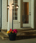 Outdoor Solar Lamp Post With Triple Head LED Lanterns And Planter Base Black Sun Powered Light near a front porch.