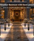 Modern Black LED Pathway Lights Sleek Cone Bollards illuminate a snowy walkway leading to a decorated entrance.