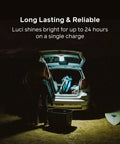 Luci Original Solar Inflatable Camping Lantern With USB C Recharge lighting up a car trunk at night during a camping trip.
