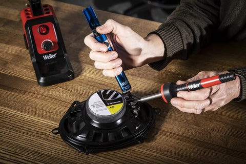 Manual ESD Safe Desoldering Pump With Aluminum Body for electronics repairs, shown in use with a soldering iron on a PCB component.
