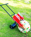 Portable Manual Garden Seeder With Dual Seed And Fertilizer Buckets on grass, featuring hand push and metal spreader roller seeder.