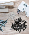 Dead Simple 30 Piece Heavy Duty Metal Furniture Joint Snap Connectors For Sofa Cabinet Assembly No Sweat Tool Free Setup For Smooth Diy Wood Fix Projects scattered on a wood surface with screws and hardware.