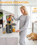 Kiamith 300W Cold Press Juicer With Huge 5.8 Inch Wide Feed Chute For Whole Produce in kitchen, woman juicing fruits.