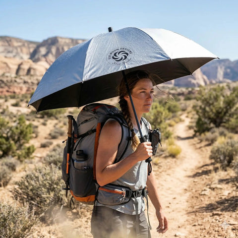 Hiker using Silver Shadow Hiking Umbrella With UPF 50 Plus Sun And Rain Protection Ultralight 8.9 Oz Fiberglass Frame in desert landscape.