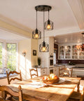 Slick Farmhouse Three Light Pendant With Adjustable Drop Cords Matte Black Hanging Ceiling Lamp above a wooden dining table.