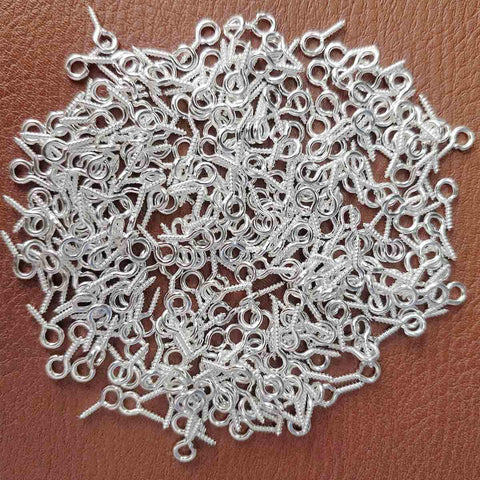 300Pcs Mini Screw Eye Pins and Hooks Set 10x5mm SelfTapping Screws in silver finish for arts and crafts on a brown surface.