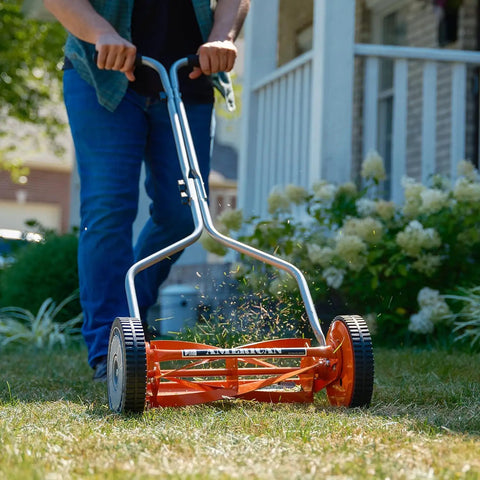 Person using 1204-14 14-Inch 4-Blade Push Reel Lawn Mower with lightweight 19-pound body, red finish, cutting grass on small lawn