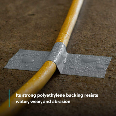 Extra Heavy Duty Duct Tape 6969, Silver, used on a yellow pipe, showcasing water resistance and abrasion resistance on concrete.
