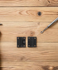 Torque Ball Bearing Hinge For Cabinets With 90 Degree Adjustable Positioning, Plastic Black Hinges Pair shown on wooden table