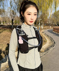 Woman wearing Lightweight Running Hydration Pack With Built In Water Reservoir Breathable Back Panel And Slim Hydration Vest outdoors