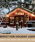 Snow-covered wooden cabin with holiday lights on roof and deck, surrounded by snow-laden trees at night.