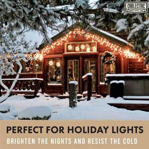 Snow-covered wooden cabin with holiday lights on roof and deck, surrounded by snow-laden trees at night.