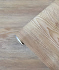 Roll of Peel And Stick Faux Wood Grain Wallpaper For Cabinets And Counters Self Adhesive Removable Oak Look with grid backing on wood surface