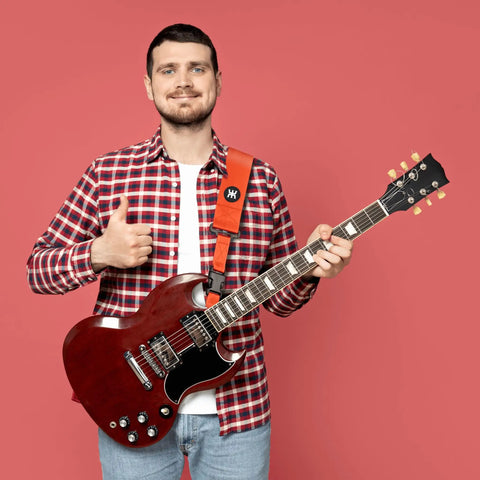Person showing SnapLock Pro Guitar Strap with Quick Release Buckle and Screw Fasten Ends on electric guitar, orange color.