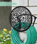 Heavy Duty Outdoor Garden Hose Reel and Wall Mount Holder With Tree of Life Metal Design mounted on a wall with green hose