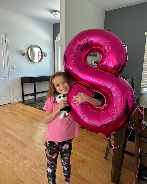 Child holding a Hot Pink Number 8 Balloon 40 Inch Giant Foil Balloon For 8th Birthday Party Decor Epic Photo Backdrop Prop.