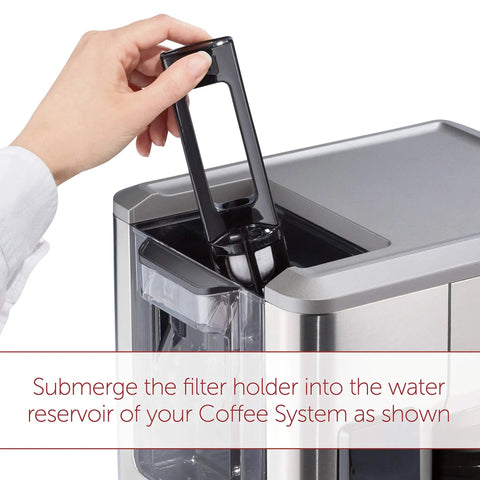 Hand inserting Six Pack Replacement Water Filter into WGCM100S coffee machine for cleaner, better tasting coffee up to 30 brews
