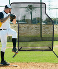 Baseball player practicing with Z Screen Pitching Net 5x7 Ft Portable Baseball Backstop on field