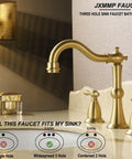Gold three-hole bathroom faucet with dual handles on a white vanity, elegant design
