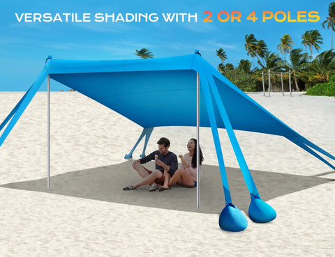 Beach Canopy Sun Shelter 10x10ft With UPF50 UV Protection on sandy beach, two people sitting underneath, blue shelter with poles and sandbags.