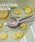 Go-To Stainless Steel Lemon Squeezer with large bowl, surrounded by sliced limes, showing 3" and 8.6" dimensions on a green background.