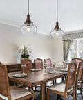 Vintage Glass Pendant Light Kitchen Island with Walnut Wood 9.8in hanging over a dining table with elegant chairs.