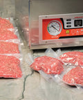 Chamber Vacuum Sealer CM255 for home and commercial kitchens with vacuum-sealed meat packs on countertop