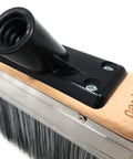 Close-up of the Deck Boss Mini 6 Inch Deck Stain Brush Applicator showcasing the handle fitting and wood base with branding.