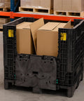 Rugged Collapsible Bulk Storage Container Featuring Four Way Forklift Access And Two Drop Doors Standard Duty Stacking Pallet Box With One Thousand Seven Hundred Pound Capacity filled with cardboard boxes.