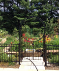 Arched Top Garden Arbor With Gate Brushed Bronze Powder Coated Outdoor Garden Archway in a serene garden setting