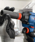 Gloved hands using Two-In-One 18V Impact Driver Kit With 1/4 Inch Quick-Change Hex And 1/2 Inch Drive, Delivers Up To 1,600 In-Lbs Torque