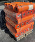Pallet of orange safety netting rolls stacked for shipment