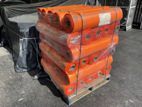 Pallet of orange safety netting rolls stacked for shipment