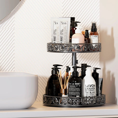 Two-tier metal Lazy Susan organizer turntable, black finish with floral filigree, 12-inch; holds bottles and pumps.