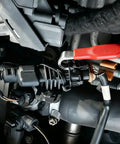 Close-up of Heavy Duty Dual Tip Automotive Pry Bar used on wiring harness clips in an engine compartment.