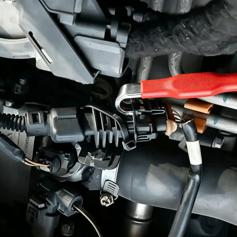 Close-up of Heavy Duty Dual Tip Automotive Pry Bar used on wiring harness clips in an engine compartment.