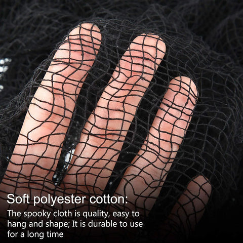Close-up of hand holding six pack matte black cotton crepe sheets, stretchy ghost fabric for yard and porch styling.