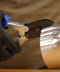Person using 5-Blade Crimper For Straight And Wide Cut Pinch-Thru Point Cutter on metal pipe with hardened steel blades.