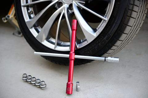 LugStrong 26 Inch Universal Compact Lug Wrench Set With Heavy Duty Tire Iron And Lug Nut Remover shown with car wheel and sockets