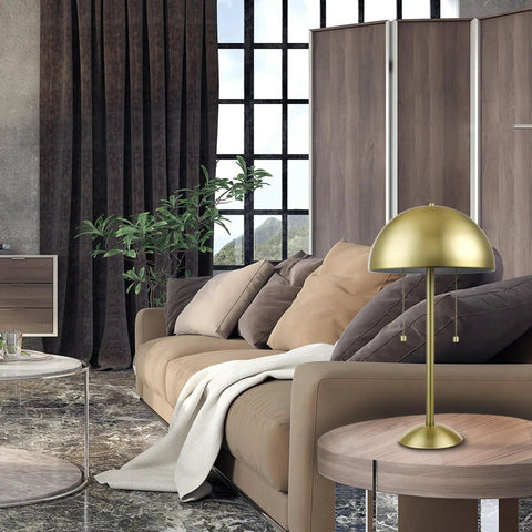 Haydel 21 Inch 2 Light Table Lamp in matte brass with dual pull chains in a modern living room setting, placed on a side table.