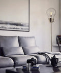 Edison Floor Lamp In Antique Brass Finish, Clear Glass Shade, Rustic Vibe, 71.5 Inch Tall illuminating a stylish living room.