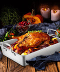 Big Turkey Roasting Pan With V Shaped Rack Stainless Steel Roaster Pan 16x11.5Inch with roast turkey and vegetables on rustic table