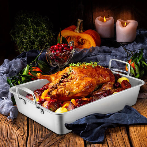 Big Turkey Roasting Pan With V Shaped Rack Stainless Steel Roaster Pan 16x11.5Inch with roast turkey and vegetables on rustic table